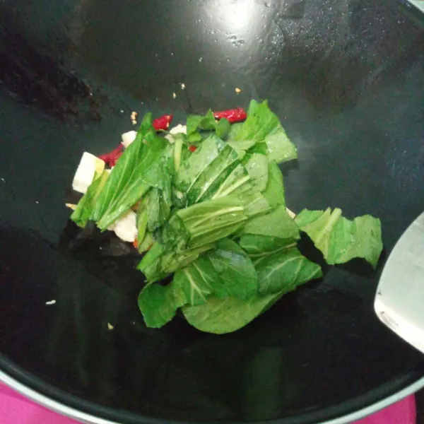 Masukkan sawi ang sudah di cuci aduk rata sampai sawi layu.