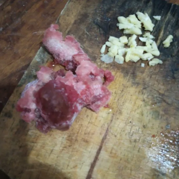 Siapkan daging giling, kemudian cincang kasar bawang putih.