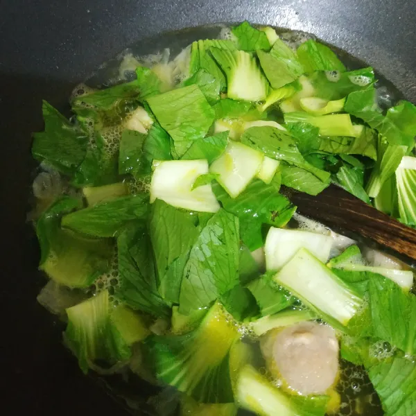 Tambahkan pakcoy, kaldu bubuk, garam, gula dan lada bubuk. Masak hingga air mendidih.