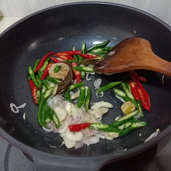 Kemudian masukkan cabai hijau dan cabai merah, aduk rata.