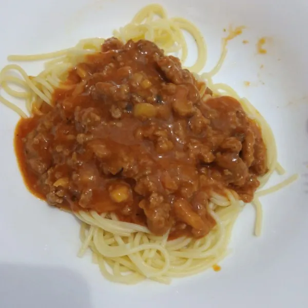 Siapkan spagheti di piring saji, kemudian tuang saus daging ke atas spagheti.