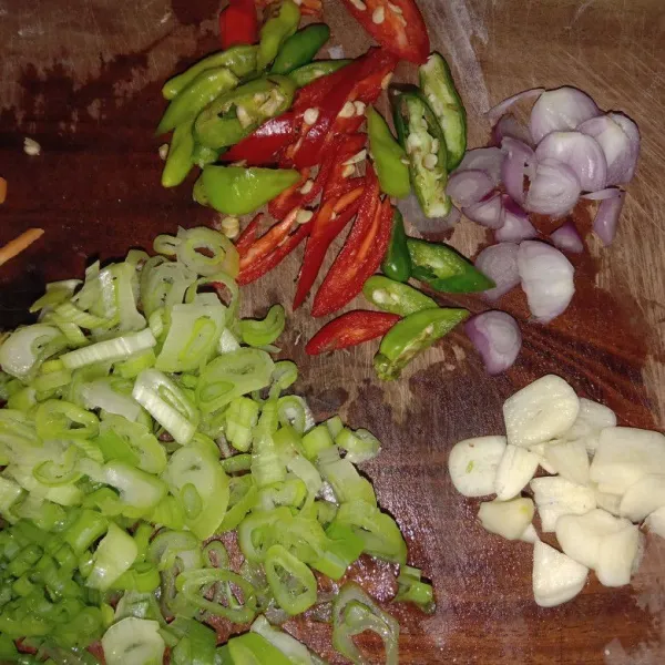 Iris tipis 1 daun bawang, 10 cabe rawir, 1 cabe merah, 1 siung bawang merah, 1 siung bawang putih lalu sisihkan
