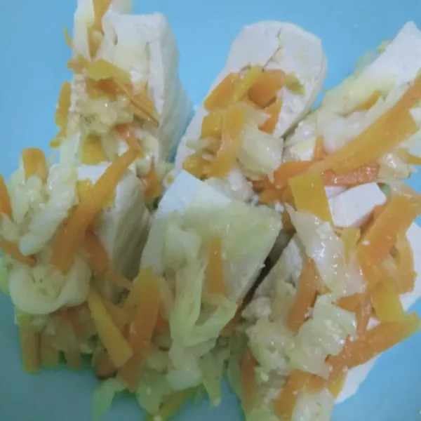 Belah dua tahu lalu korek tengahnya, isi dengan tumisan tadi.