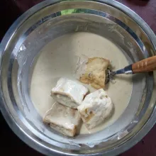 Masukkan tahu ke dalam adonan pelapis, balur ke seluruh permukaan tahu.