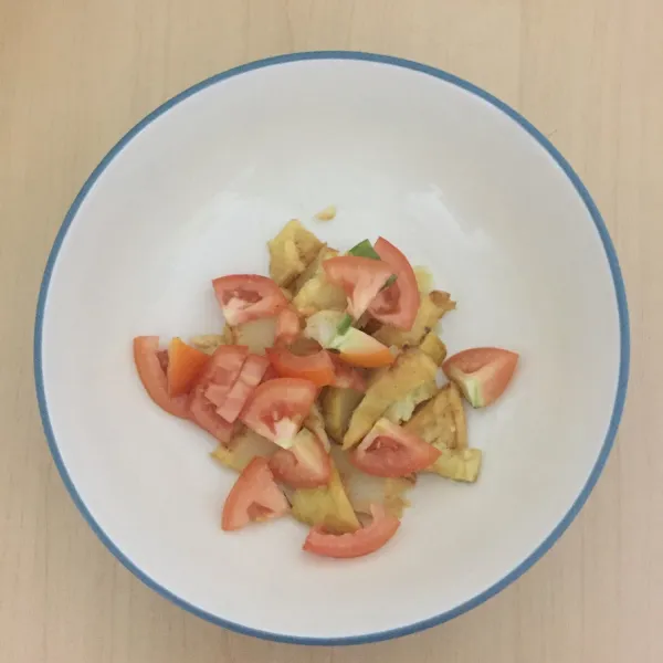 Masukkan potongan kentang dan tomat ke dalam mangkuk saji.