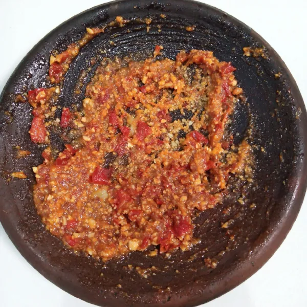 Goreng bawang putih, cabai merah dan cabai rawit sampai layu. Kemudian ulek bersama gula merah dan garam sampai halus