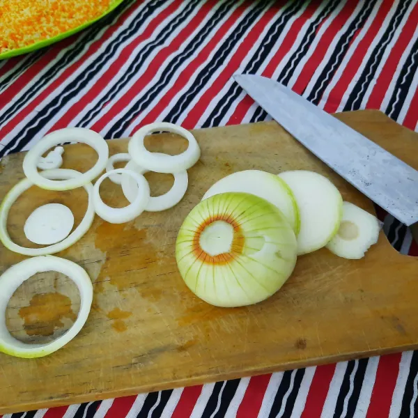 Potong bawang bombay secara melintang dan pisahkan.