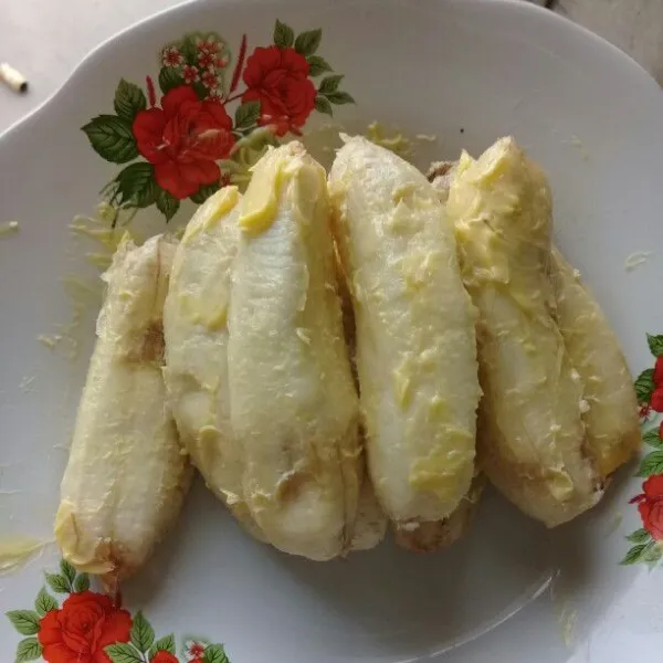 Kupas pisang lalu olesi dengan margarine.