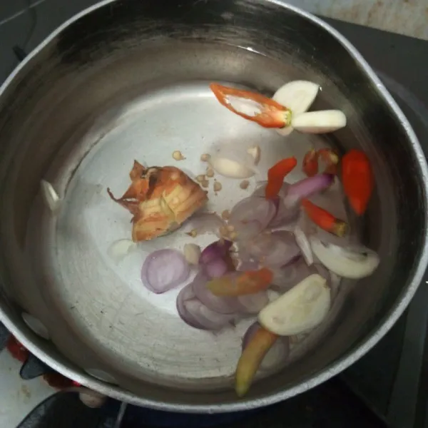 Rebus air masukkan bawang merah, bawang putih, cabai dan lengkuas. Masak sampai mendidih