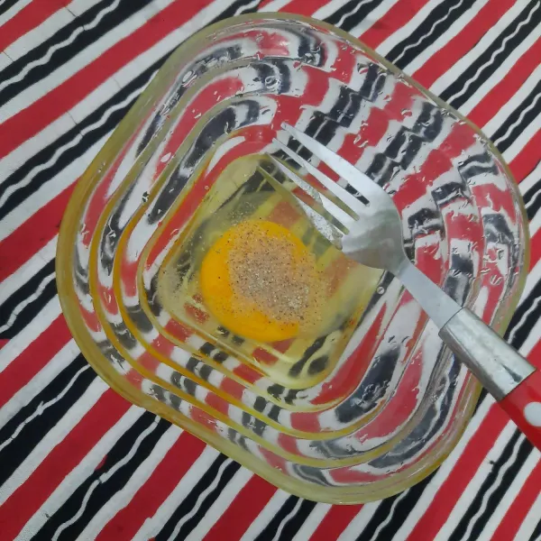 Kocok satu butir telur dan taburkan lada bubuk secukupnya.