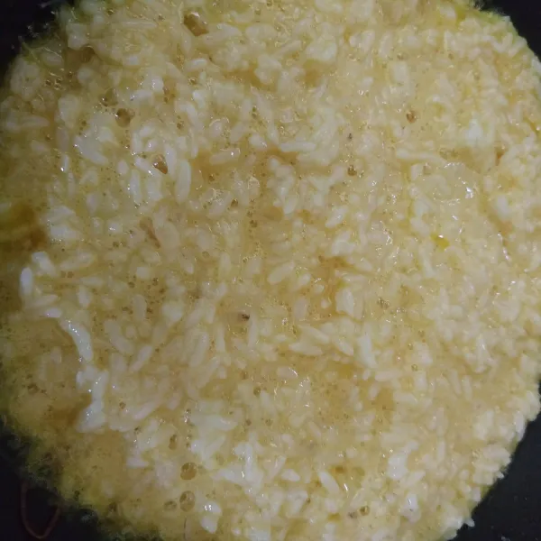 Lelehkan margarine, masukkan telur dan nasi yang sudah tercampur rata.