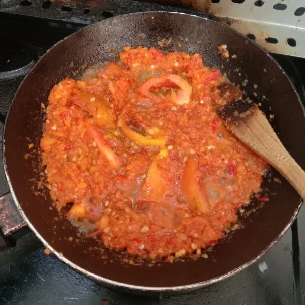 Masukkan potongan tomat, tumis lagi hingga tomat layu dan hancur, aduk rata.
