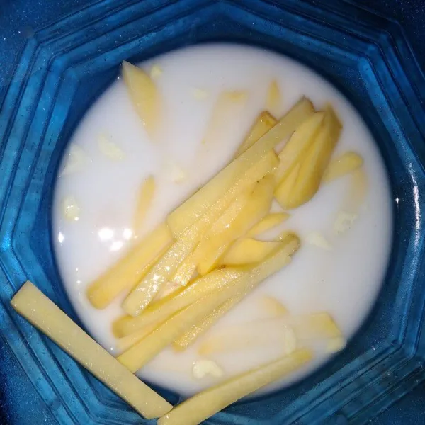 Rendam potongan kentang pada campuran tapioka, bawang putih, garam dan air