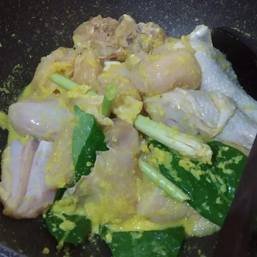 Masukkan bumbu halus, serai, daun salam, garam, gula dan ayam ke dalam panci tanpa menambahkan minyak. Lalu aduk rata.