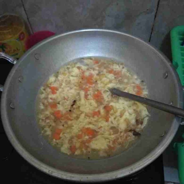 Masukkan telur kocok, biarkan 5 detik lalu aduk melingkar agar membentuk serabut.