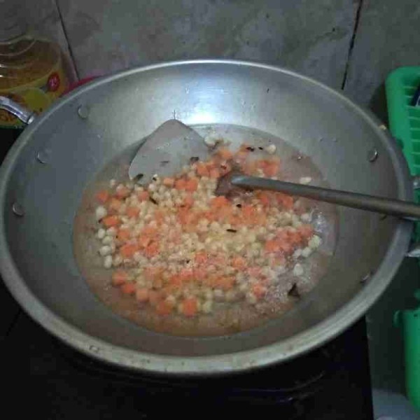 Tambahkan air, biarkan mendidih. Lalu masukkan jagung dan wortel. Bumbui dengan garam, lada dan kaldu bubuk.