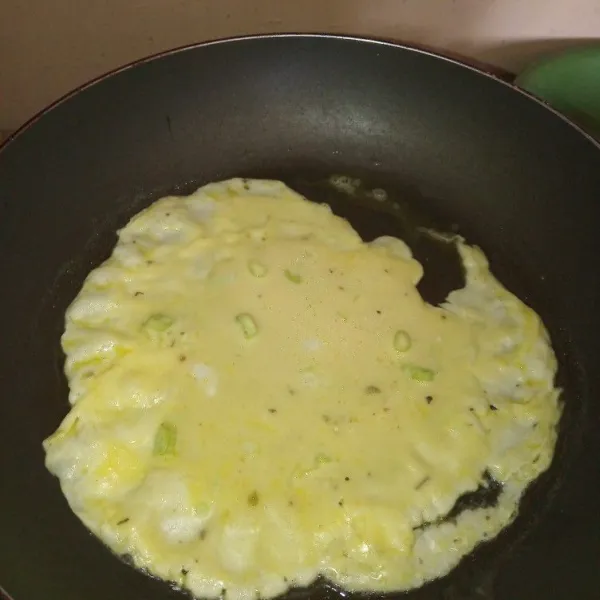 Tuang adonan telur ke dalam teflon sedikit demi sedikit, ratakan.