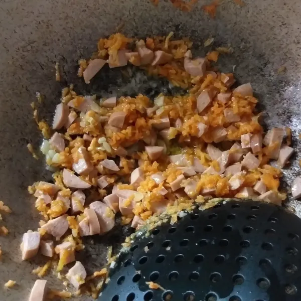 Panaskan wajan, masukkan margarin tunggu hingga meleleh, kemudian tumis bawang putih hingga harum. Masukkan wortel dan sosis, tumis sebentar.