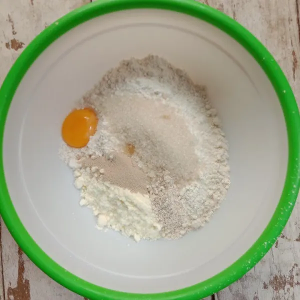Masukkan dalam bowl tepung terigu, gula, kuning telur, ragi instant dan susu bubuk.
