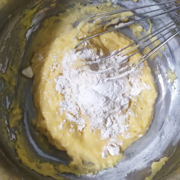 Tambahkan tepung terigu perlahan sambil diaduk. Tambahkan pula air agar tidak menggumpal.