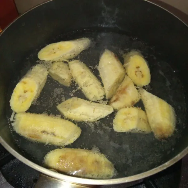 Kupas pisang, potong masing-masing pisang jadi 3 bagian.