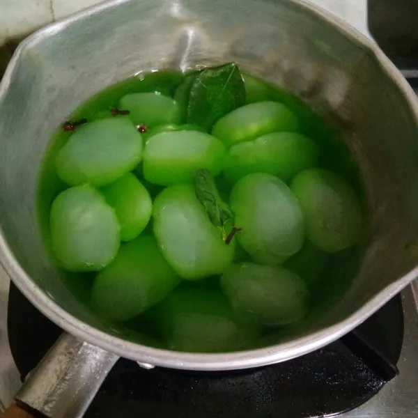 Masukkan kolang kaling ke dalam panci. Tambahkan 200 ml air, gula pasir, sirup rasa melon, daun jeruk dan cengkeh. Aduk rata, masak hingga meresap dan air menyusut.