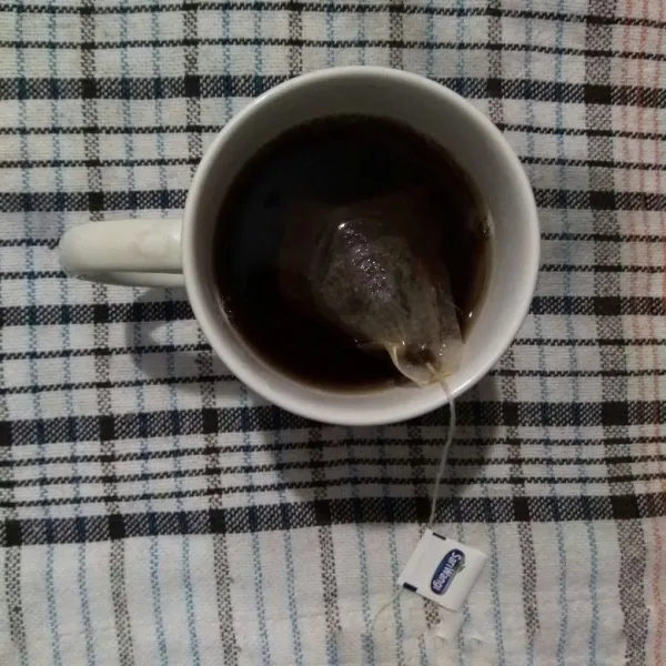 Seduh teh celup dengan air panas.