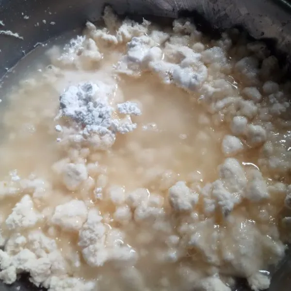 Siapkan wadah, masukkan singkong yang sudah diperas. Tambahkan gula, garam dan tepung ketan. Siapkan air panas lalu siramkan, aduk hingga tercampur rata.