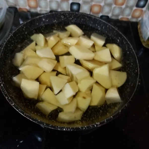 Potong besar dan goreng kentang hingga 1/2 matang.