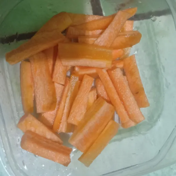 Selagi menunggu ikan dimarinasi, potong wortel berbentuk korek api.