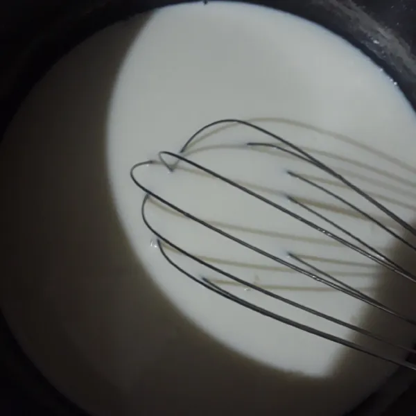 Panaskan susu dan gula pasir aduk hingga gula larut dan mendidih. Gunakan api kecil.