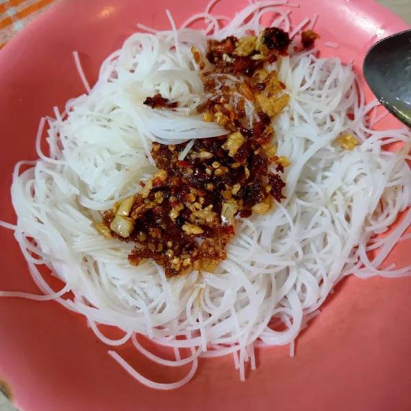 Tuang bihun dalam piring, tambahkan minyak cabe, aduk hingga rata. Sajikan dengan taburan keju parut