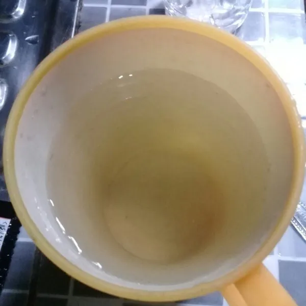 Masukkan gula pasir dan air panas ke dalam gelas aduk rata, tambahkan air dingin.