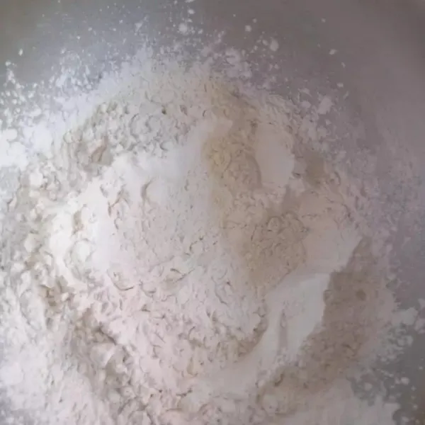 Tambahan sisa tepung secara bertahap, aduk dengan sutil kayu hingga adonan bisa dipulung, jika tepung masih sisa, hentikan penambahan tepung.