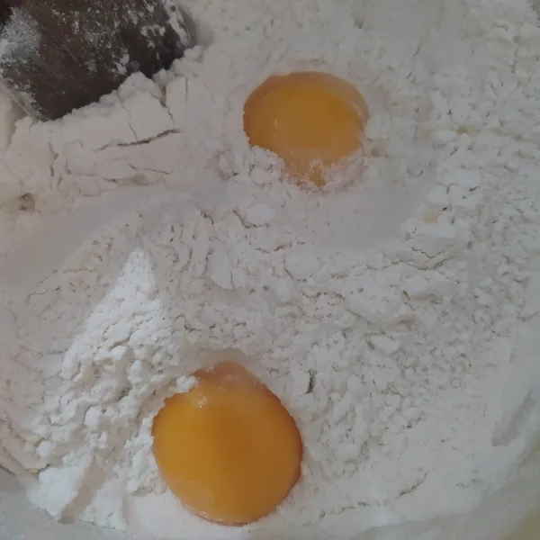 Pertama satukan tepung dan kuning telur, aduk dengan spatula, digelas campur gula dan air aduk sampai rata.