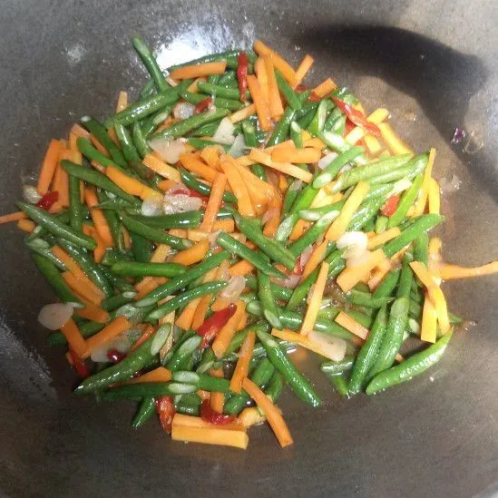 Masukkan wortel dan kacang panjang. Aduk rata dan masak hingga sayuran setengah matang.