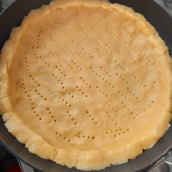 Masukkan adonan ke dalam teflon, ratakan adonan k edalam teflon. Lalu tusuk-tusuk adonan dengan garpu