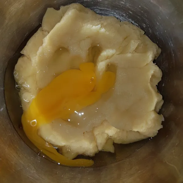 Setelah adonan tidak panas, masukkan 1 butir telur. Aduk hingga rata.
