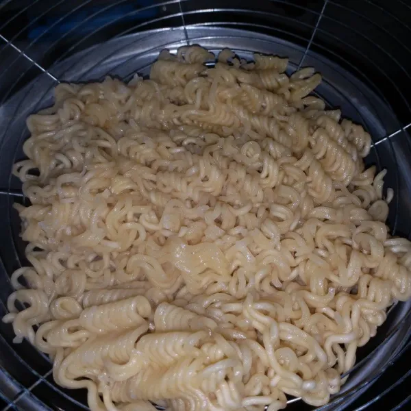 Rebus mie instan 1 menit saja, tiriskan dan buang airnya.