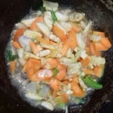 Masukkan sayuran, aduk rata, beri air. Masak hingga sayuran matang dan empuk