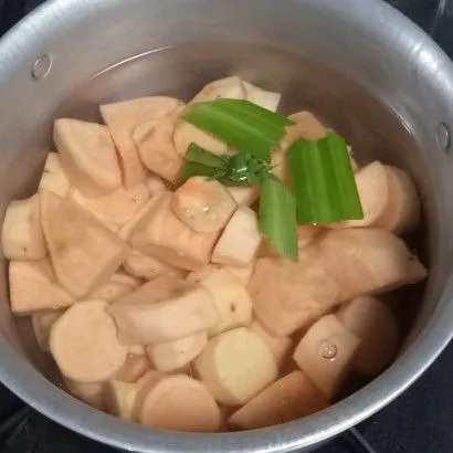 Siapkan panci, masukkan air, ubi dan daun pandan. Lalu masak hingga ubi setengah matang.