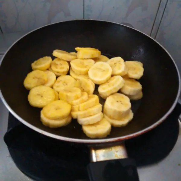 Iris pisang, lalu panaskan margarine, panggang sebentar pisang dengan teflon.