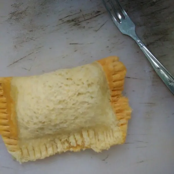 Lipat roti lalu kerat bagian sisinya dengan garpu.