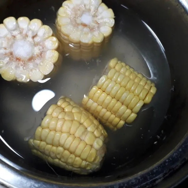 Potong 4 bagian dari 1 buah jagung manis, masukkan dalam panci beri air secukupnya.