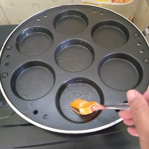 Panaskan cetakan, oles dengan mentega. Gunakan api sangat kecil saja.