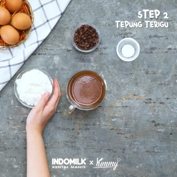 Tambahkan tepung terigu, baking powder, dan chocolate chip, lalu aduk hingga rata kembali dan masukan ke dalam ramekin