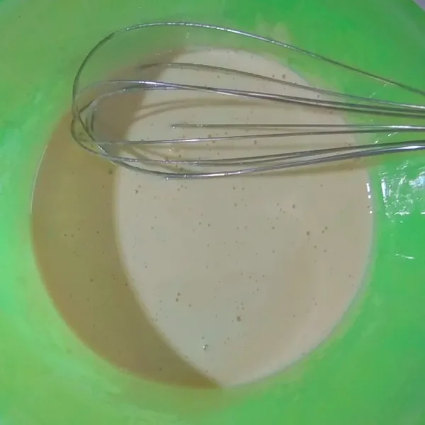 Campur gula dengan telur. Aduk dengan whisk sampai adonan mengembang dan berwarna kuning pucat.