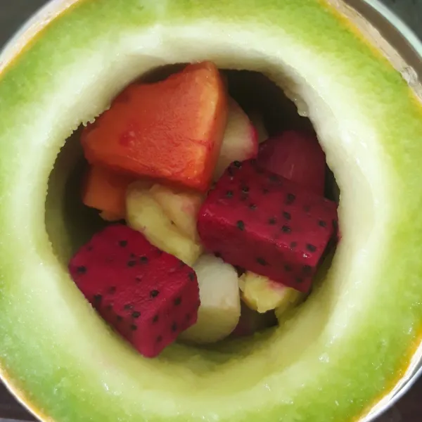 Masukkan potongan buah tadi ke dalam melon hingga penuh. Jika sudah sisihkan terlebih dahulu.