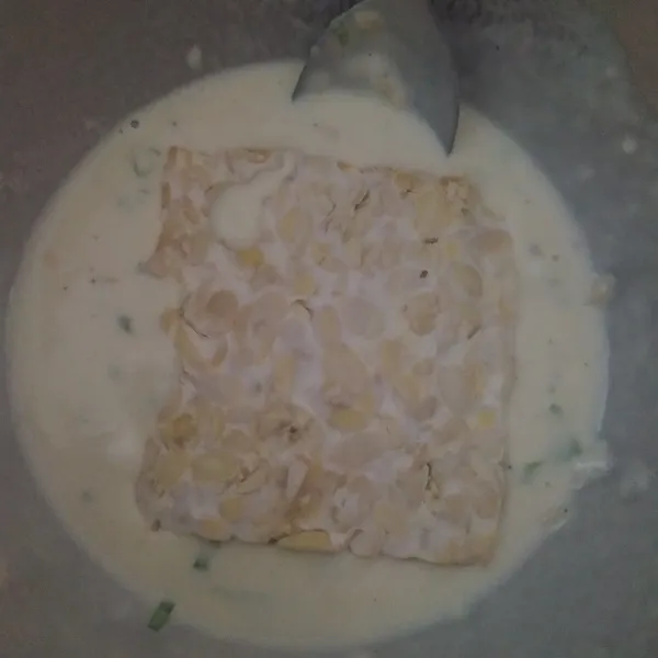 Celupkan tempe satu persatu ke dalam adonan tepung.