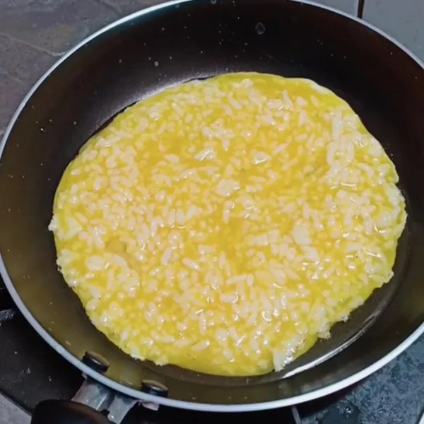 Tuangkan merata kocokan berisi nasi dan telur ke dalam teflon yang sudah di panaskan dengan minyak sebelumnya.